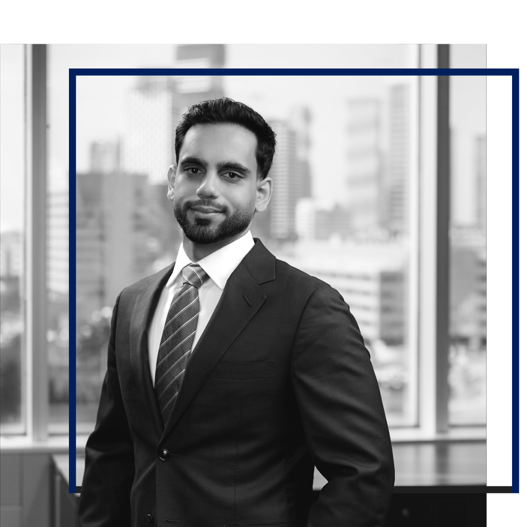Student lawyer in suit smiling at camera. Mississauga skyline blurred in the background.