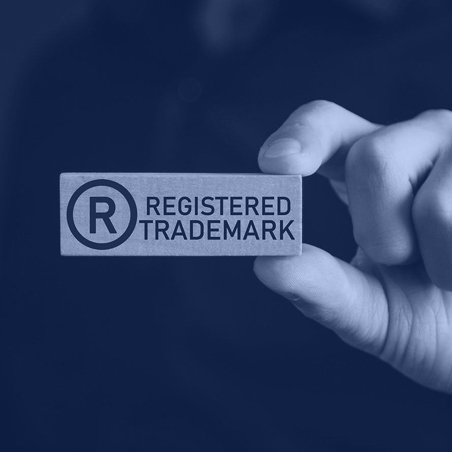 male-hand-showing-rregistered-trademark-wooden-block-backgroud